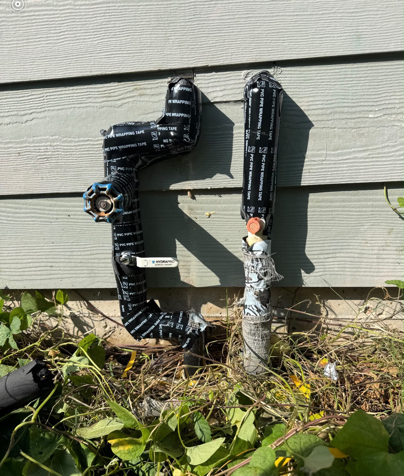 Outdoor water lines wrapped in PVC pipe-wrapping tape for UV and freeze protection in Houston 77027