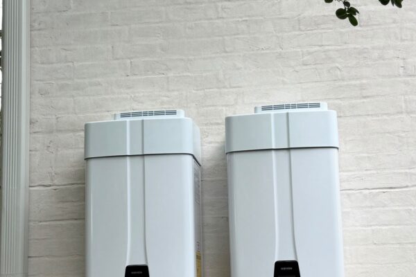 Two high-efficiency tankless water heaters mounted side by side on a Houston home in the Upper Kirby area (77027)
