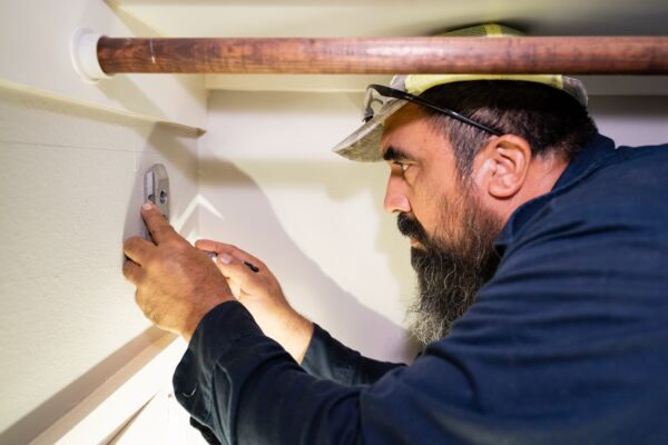 Texas Premier Plumbing technician inspecting a residential plumbing connection in a Houston home