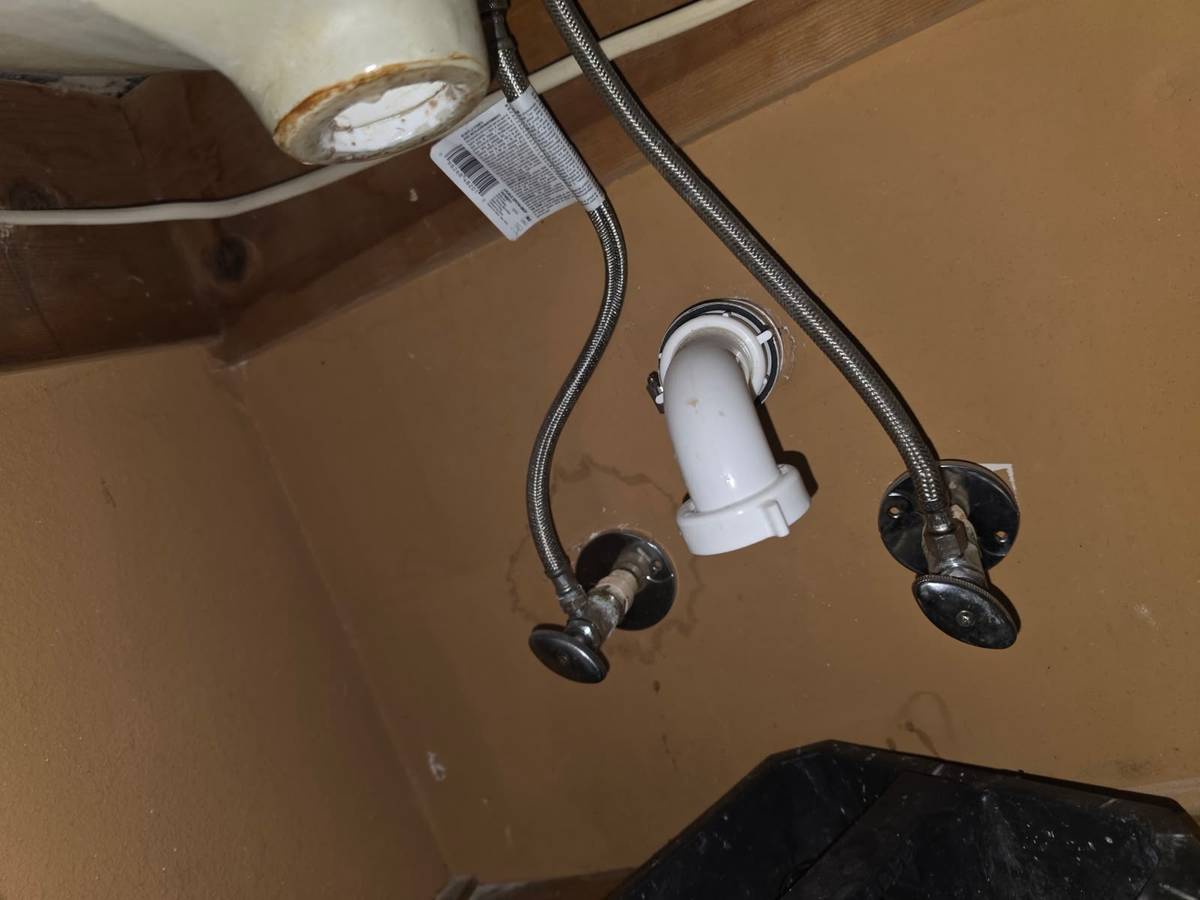 Braided supply lines and new drain elbow under a bathroom sink in Katy TX 77450