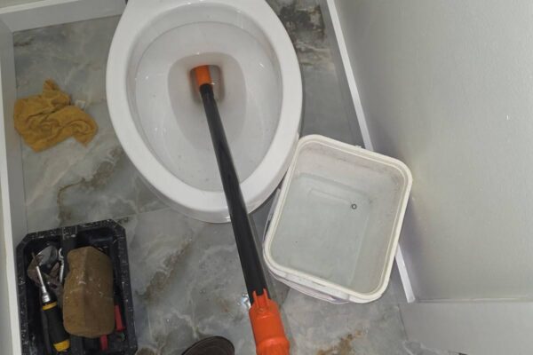 Closet auger clearing a clogged toilet in Meyerland Houston 77096