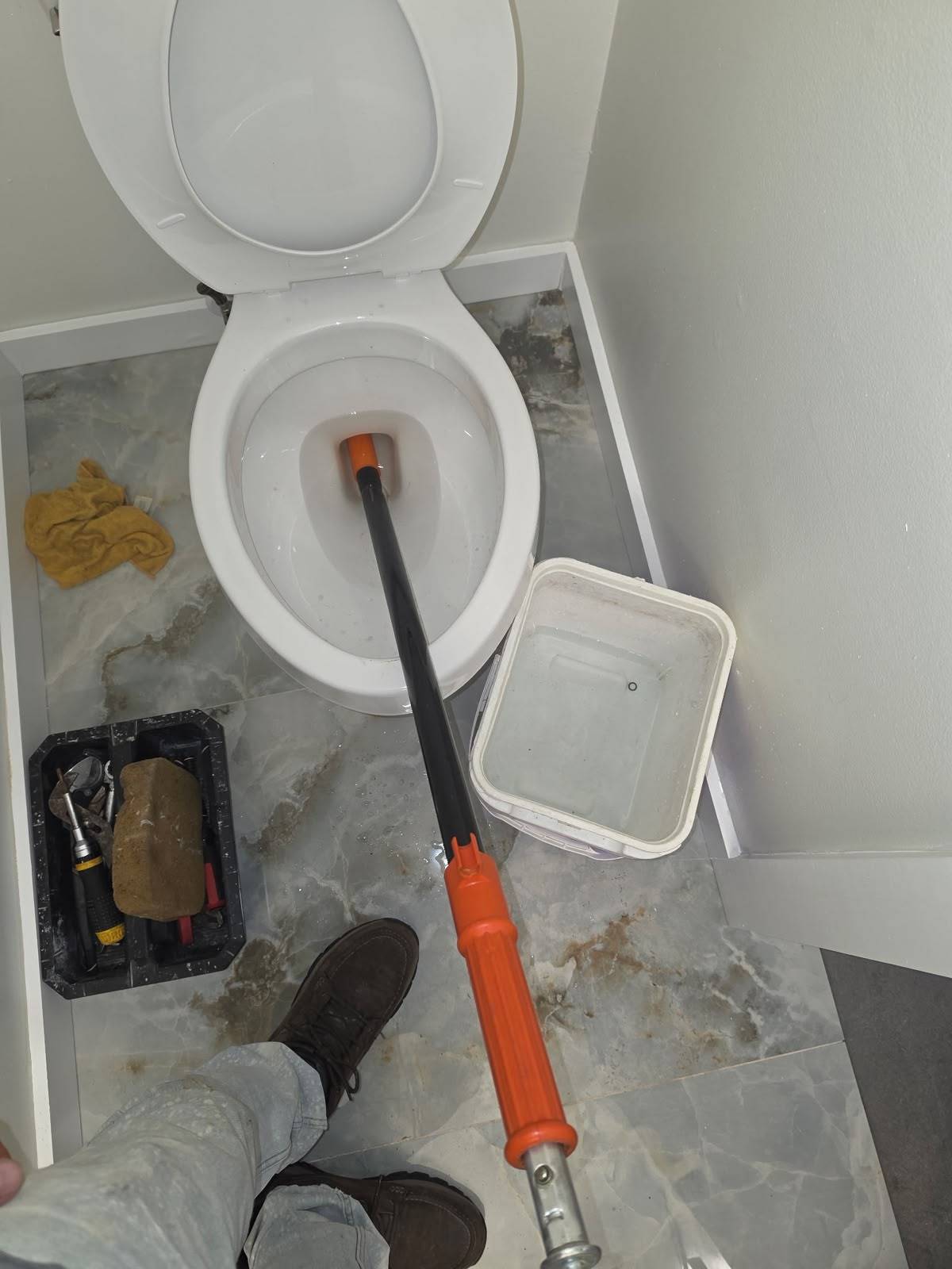 Closet auger clearing a clogged toilet in Meyerland Houston 77096